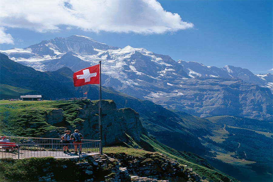 Switzerland. get natural. Hikers near the arrival point of the Wengen - Maennlichen Railway in the Bernese Oberland. In the back rises the Jungfrau.  Schweiz. ganz natuerlich. Wanderer bei der Bergstation der Wengen - Maennlichen Bahn im Berner Oberland. Im Hintergrund die Jungfrau.  Suisse. tout naturellement. Randonneurs pres de la station d'arrivee du chemin de fer a Wengen - Maennlichen dans l'Oberland bernois. Vue de la Jungfrau au fond.  Copyright by: Switzerland Tourism  By-Line: swiss-image.ch/Walter Storto