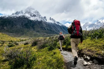 Best Hiking Trails a group of people walking on a trail in a snowy valley