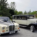 a couple of vintage cars parked in a driveway